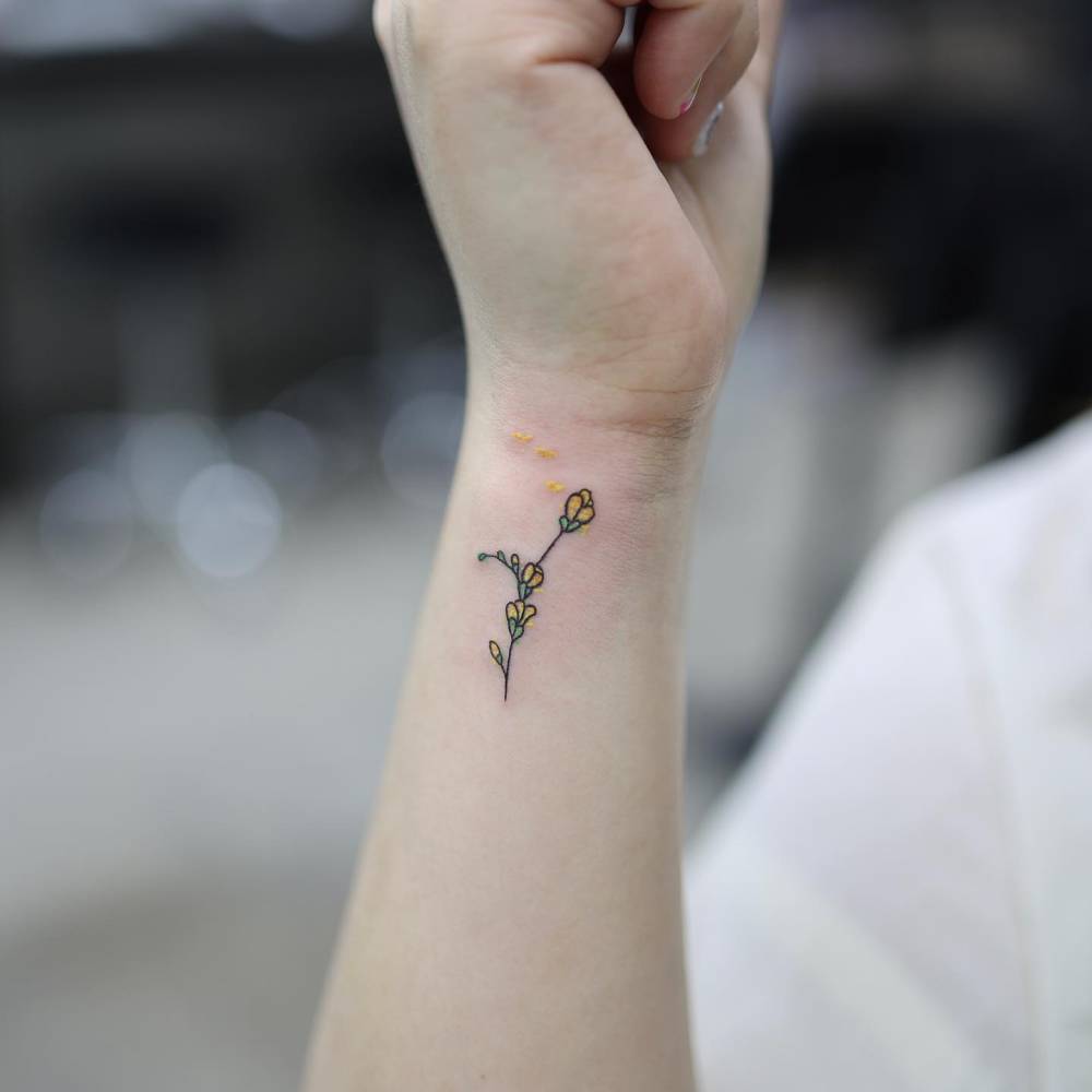 Illustrative style flowers tattoo located on the wrist.