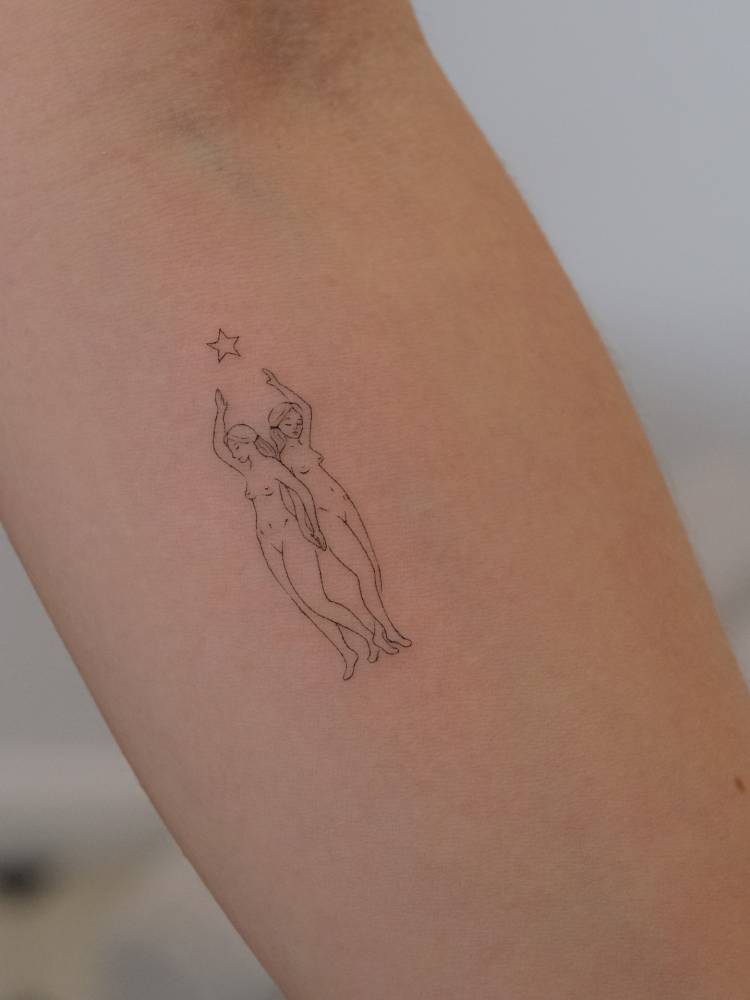 Nude ladies tattoo in fine line style, located on the inner forearm.