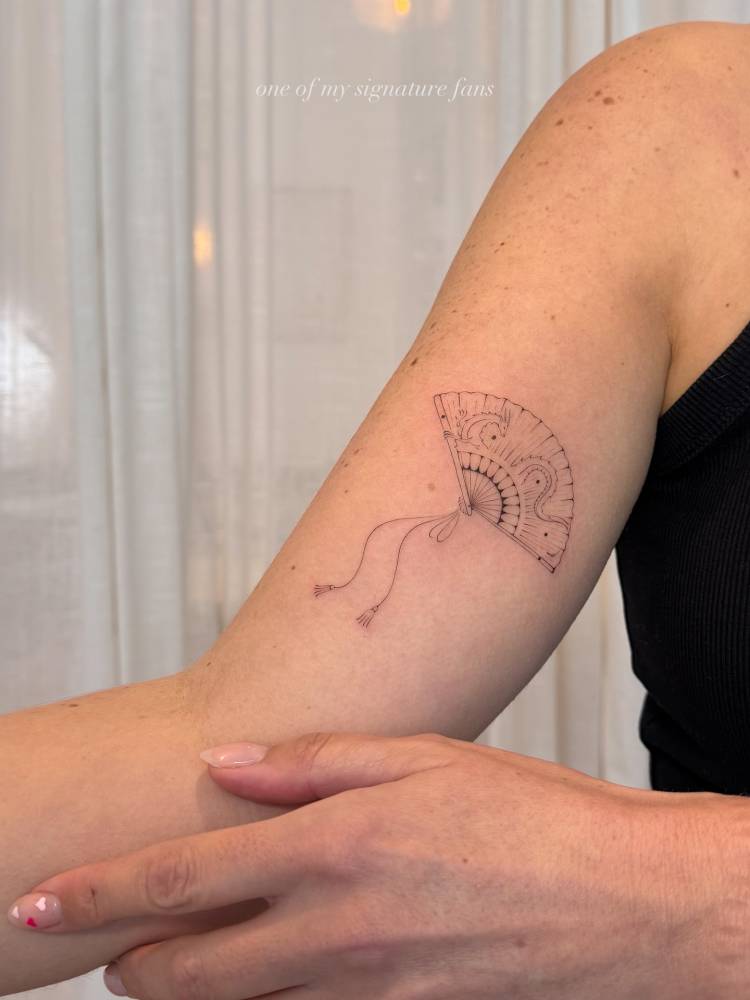 Hand fan tattoo placed on the inner arm, done in fine line style.