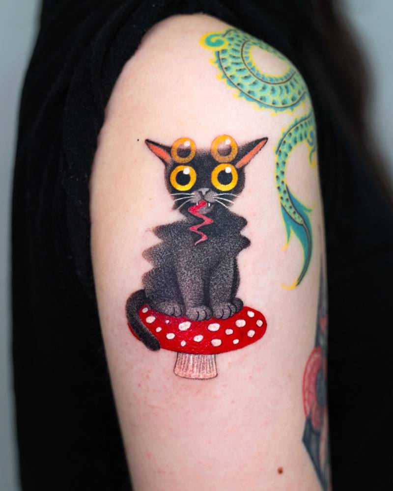 Black trippy cat on a red mushroom tattoo