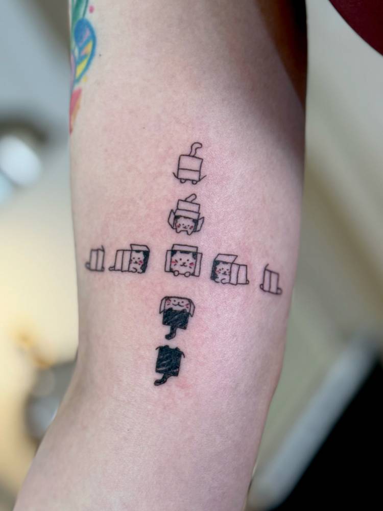 Cartoon style cats tattoo located on the inner arm.