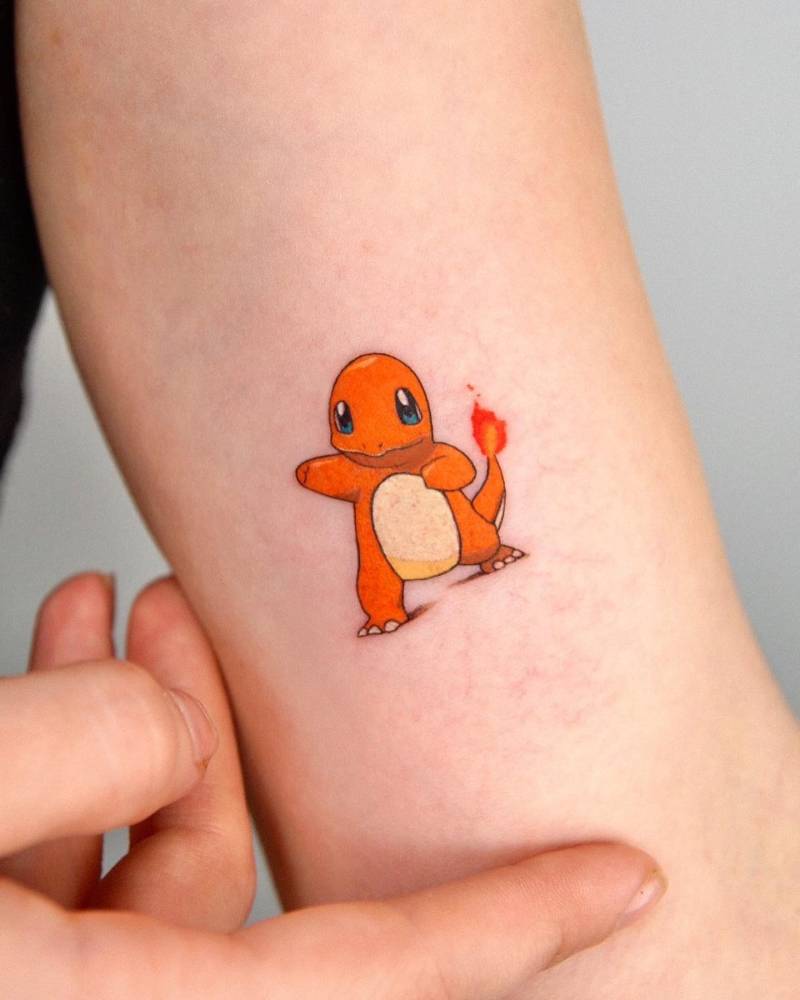 Charmander tattoo located on the inner arm, cartoon style.