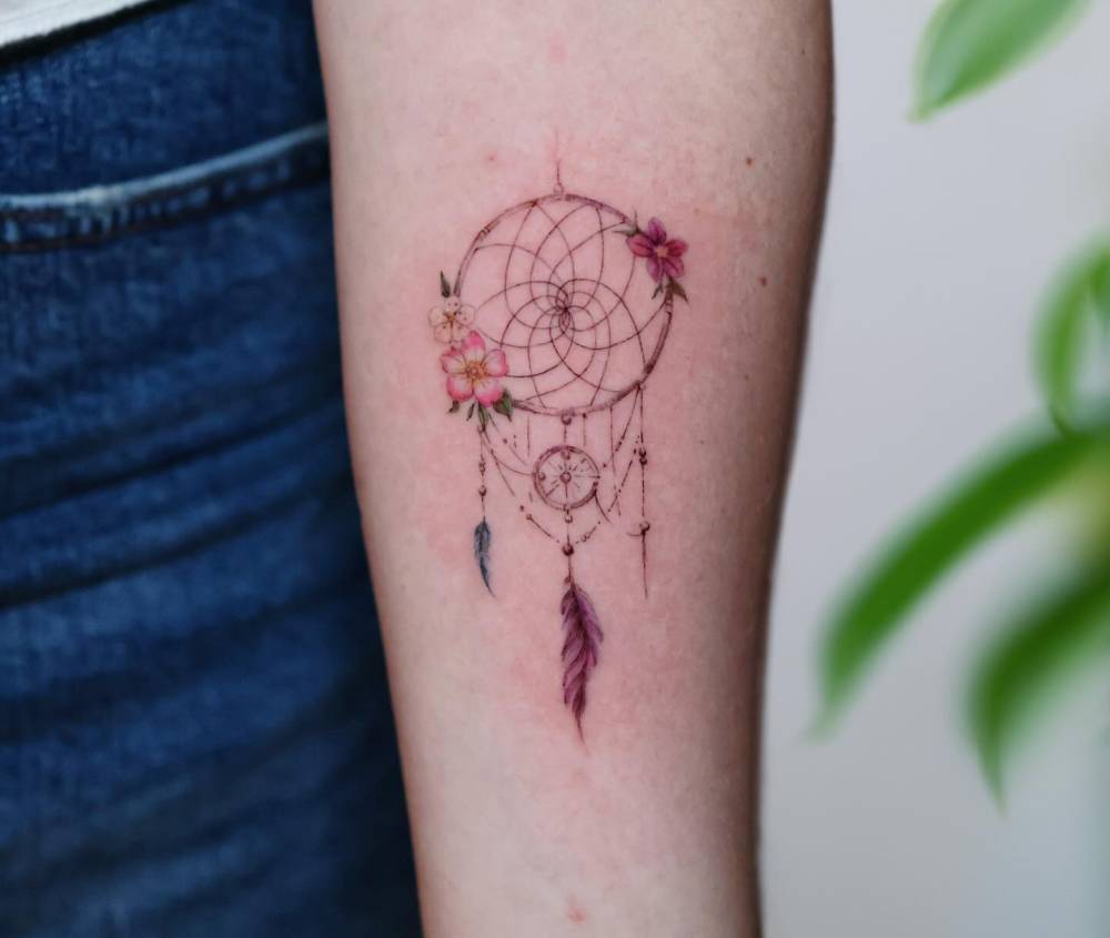 Illustrative style dreamcatcher tattoo placed on the inner forearm.