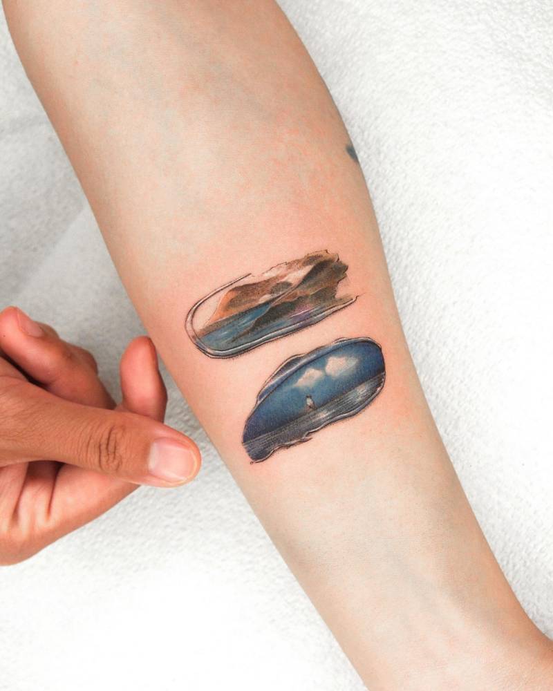 Watercolor style brush strokes tattooed on the inner forearm.