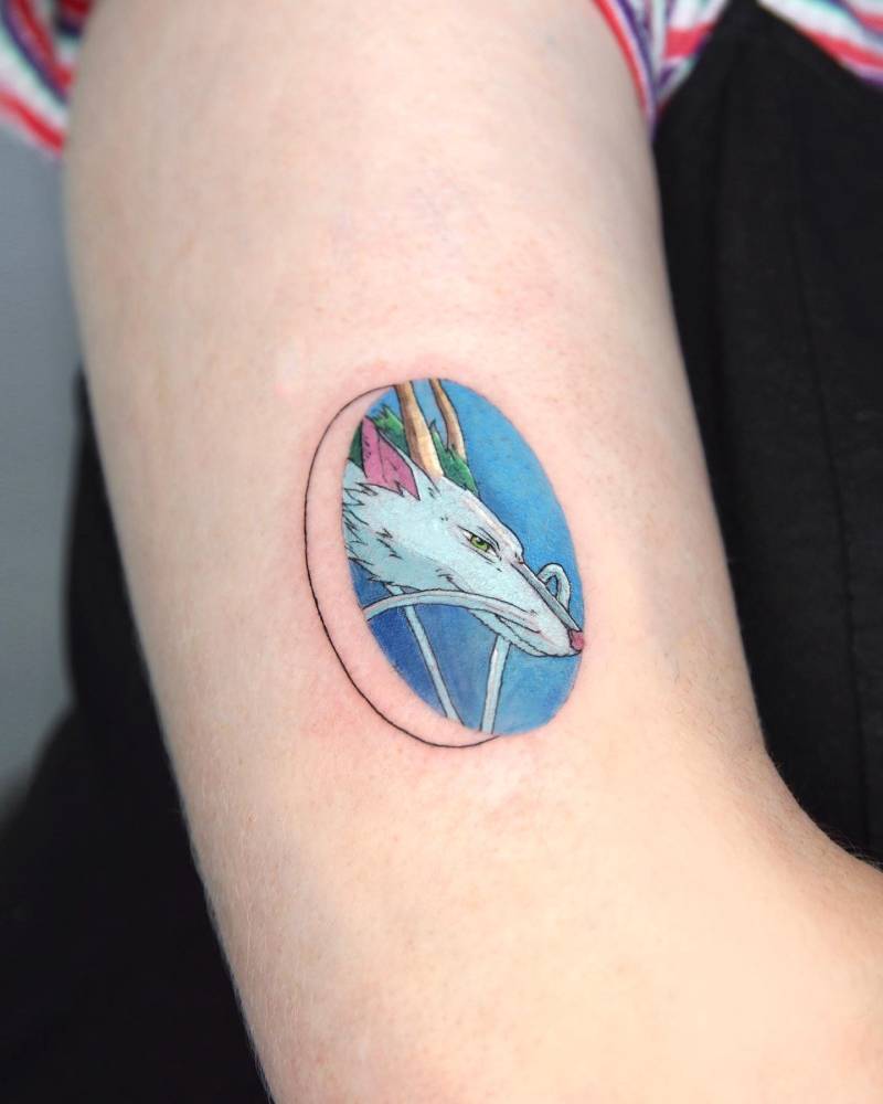 Haku portrait tattoo located on the upper arm, cartoon style.