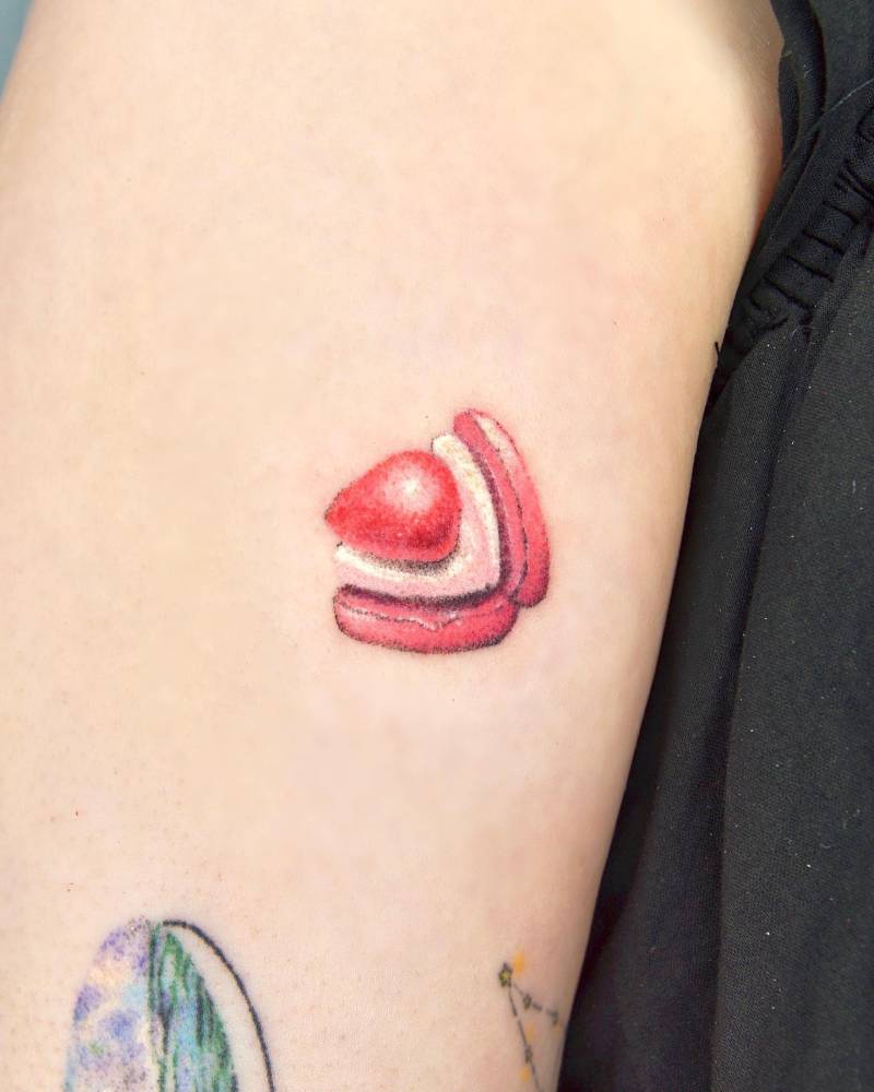 Hand poked macaron tattoo located on the upper arm.