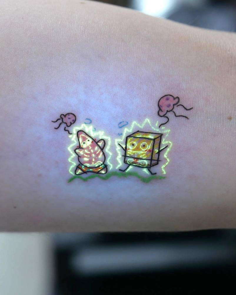 UV ink cartoon style Spongebob and Patrick Star tattoo done on the inner arm.
