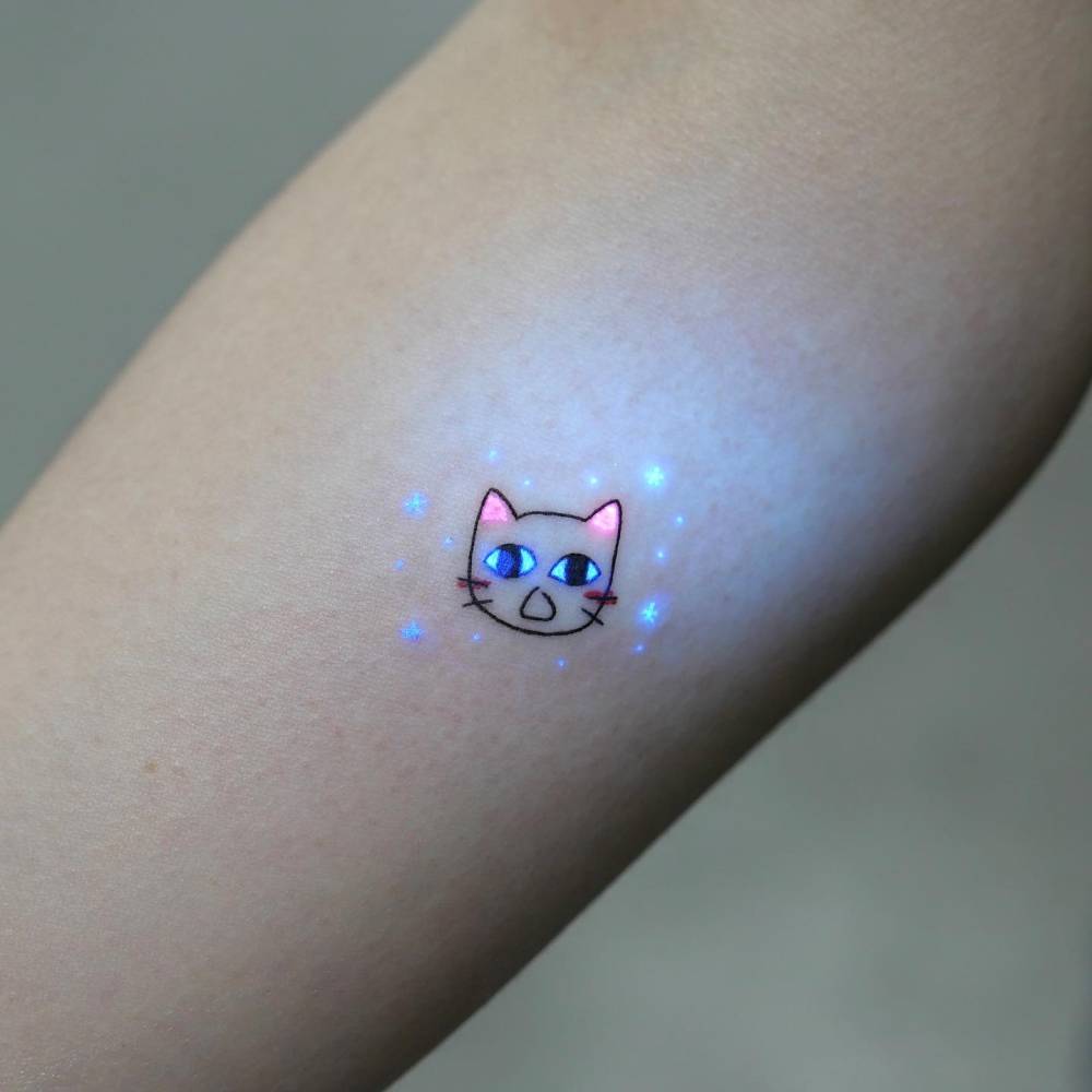 Minimalistic cat portrait tattoo located on the inner forearm.