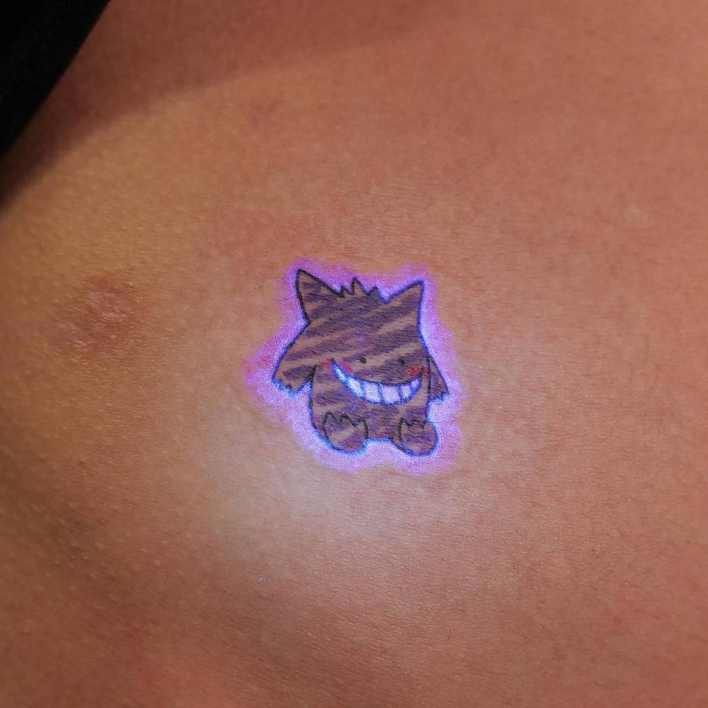 Haunter tattoo located on the waist, cartoon style.