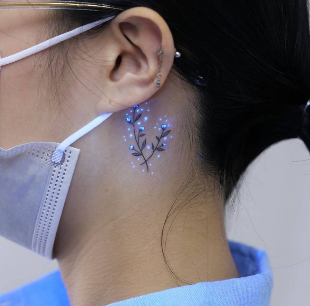 UV ink baby's breath tattoo located behind the ear.