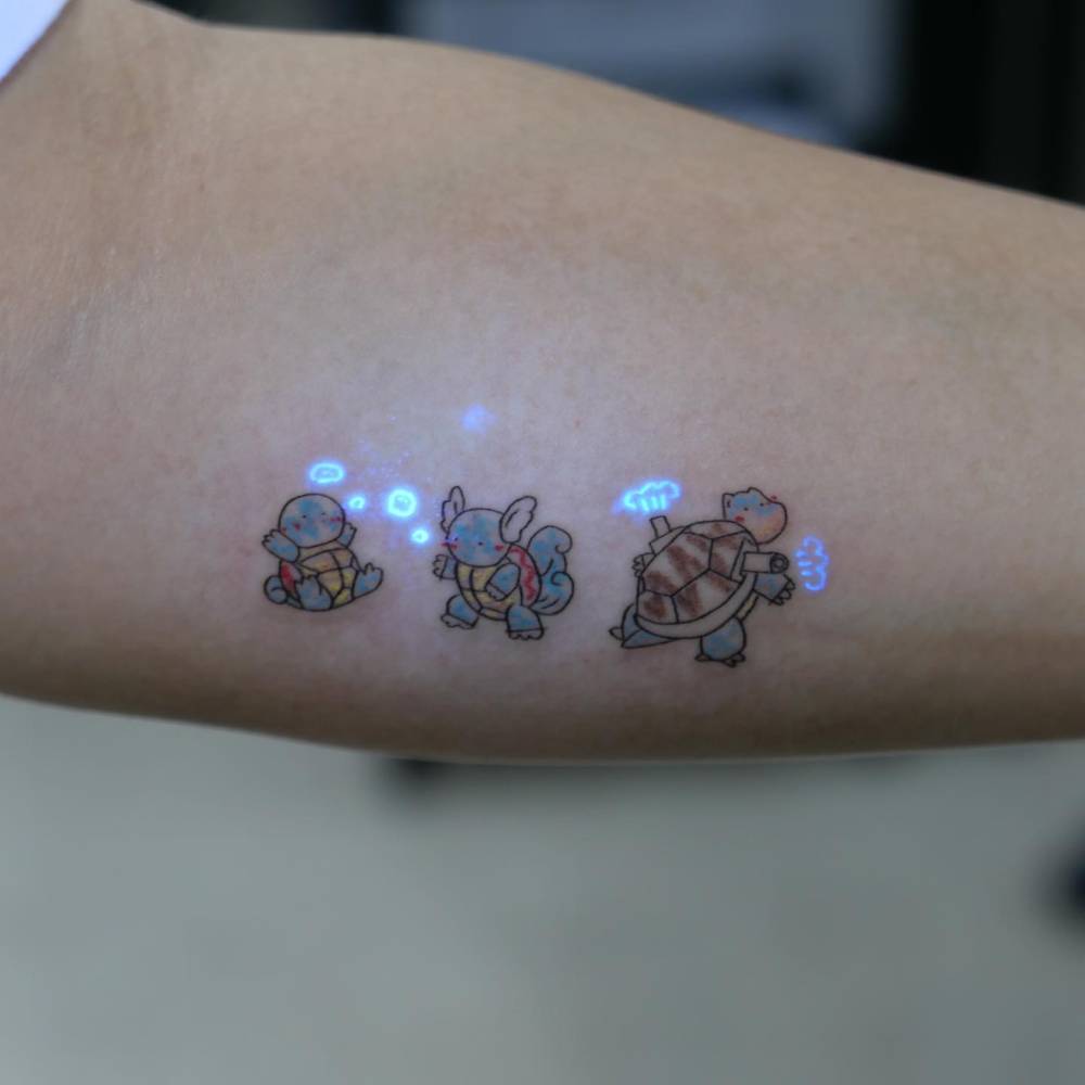 Squirtle, Wartortle and Blastoise tattooed on the inner forearm.