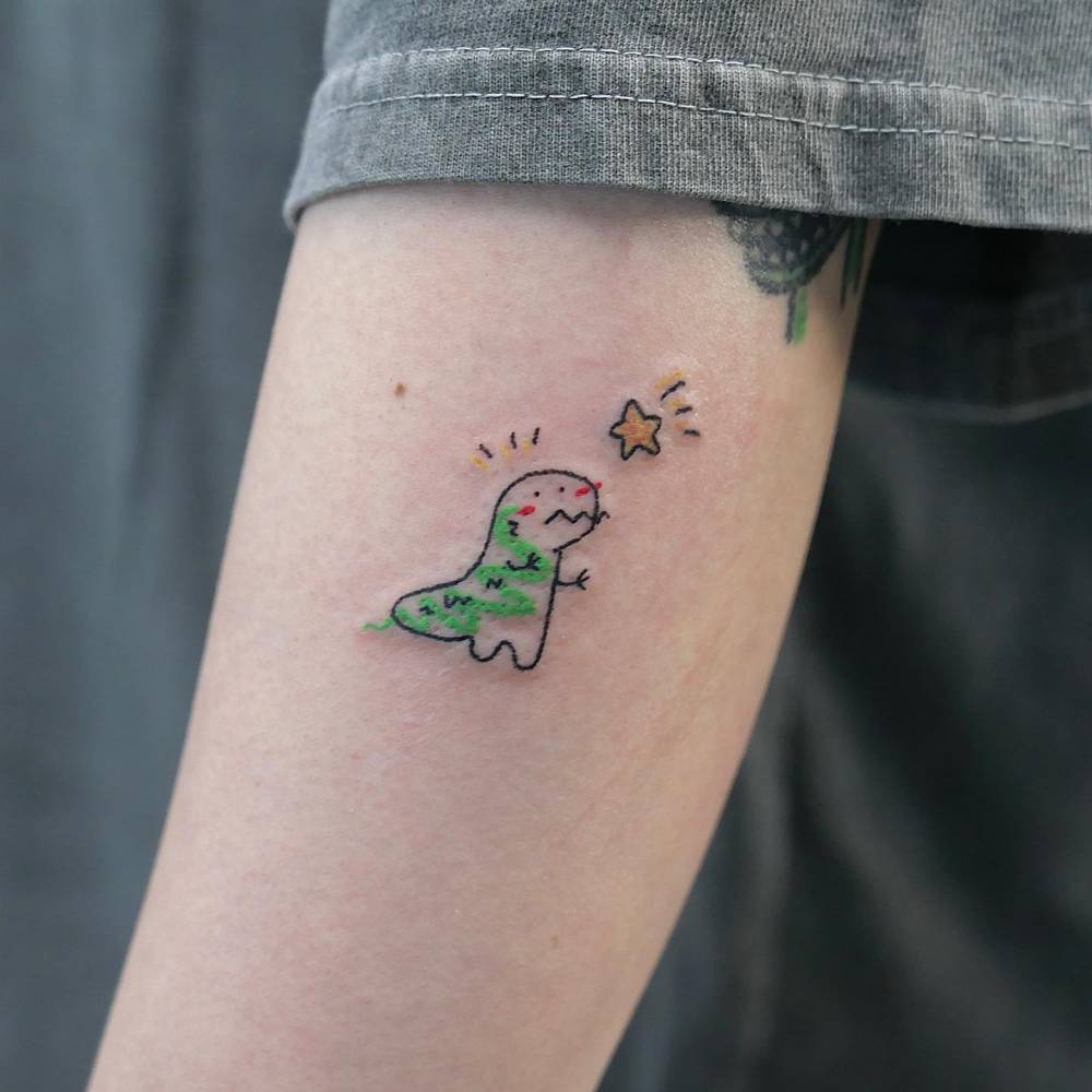 Cartoon style T-Rex tattoo located on the forearm.
