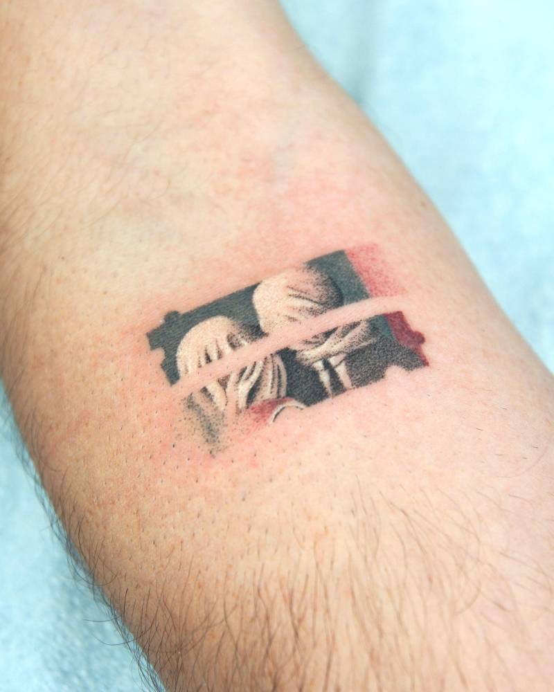 Magritte's 'The Lovers" tattooed on the inner forearm.