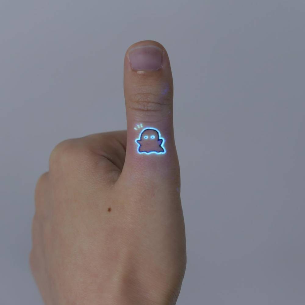 Tiny minimalistic ghost tattoo located on the thumb.