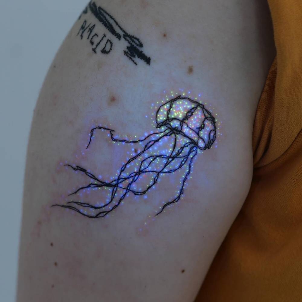 Illustrative style jellyfish tattoo done on the upper arm.