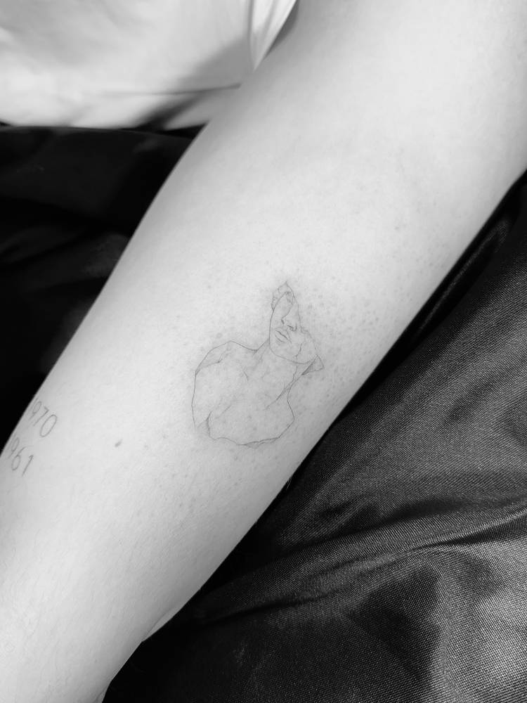 Greek sculpture tattoo in fine line style located on the forearm.