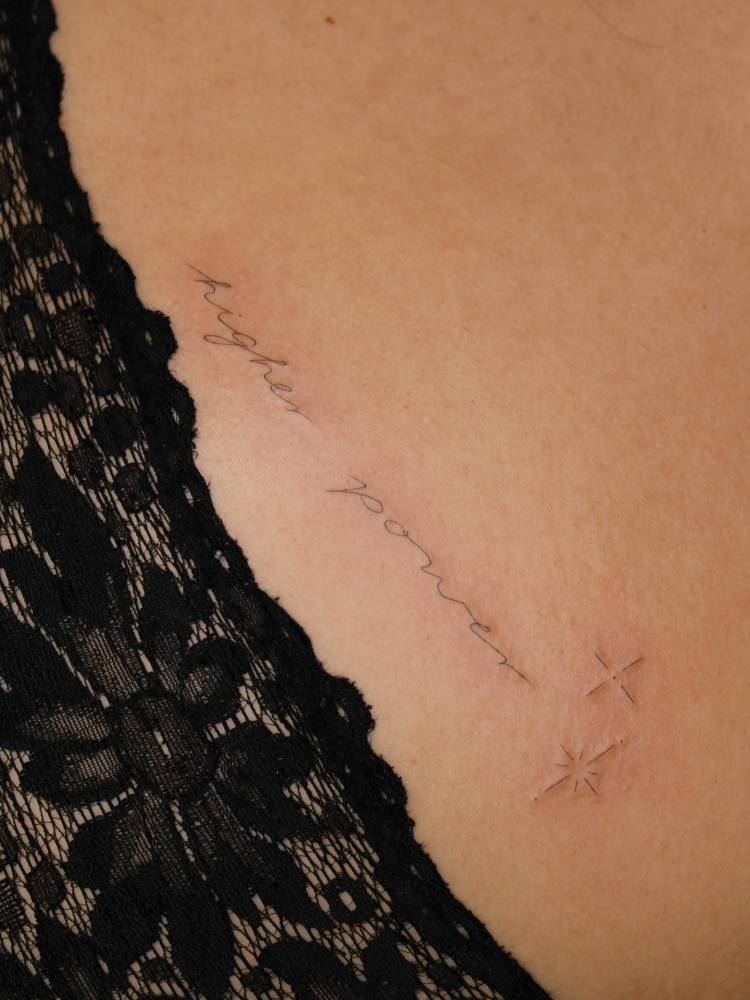 "Higher power" lettering tattoo placed on the hip.