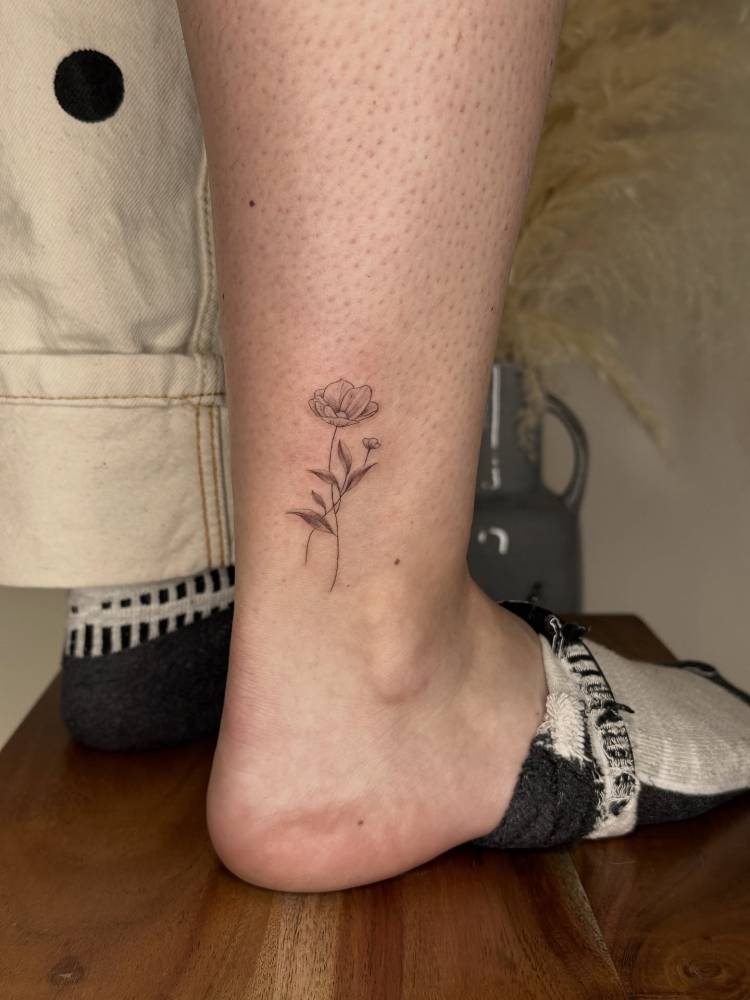 Illustrative style flowers tattoo placed on the ankle.
