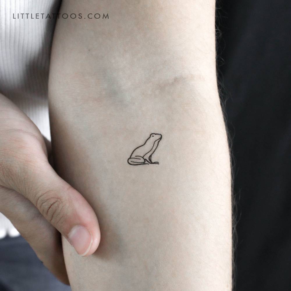 Frog temporary tattoo in minimalistic style located on the inner forearm.