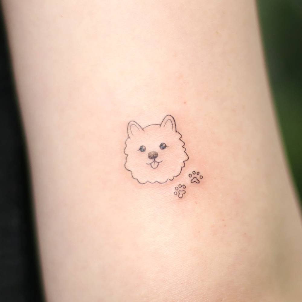 Minimalistic style Pomeranian portrait tattoo placed on the tricep.