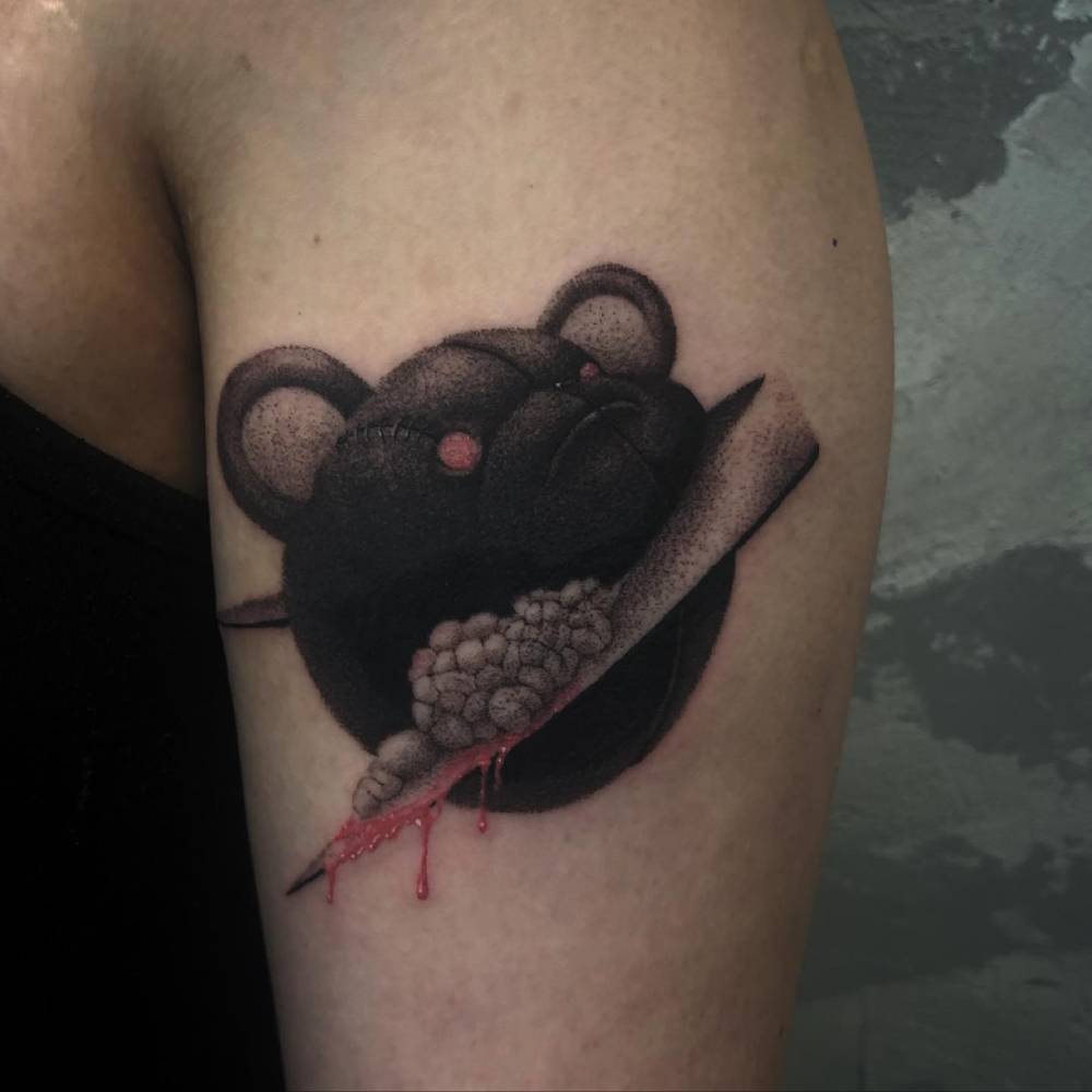 Scary teddy portrait tattoo located on the upper arm.