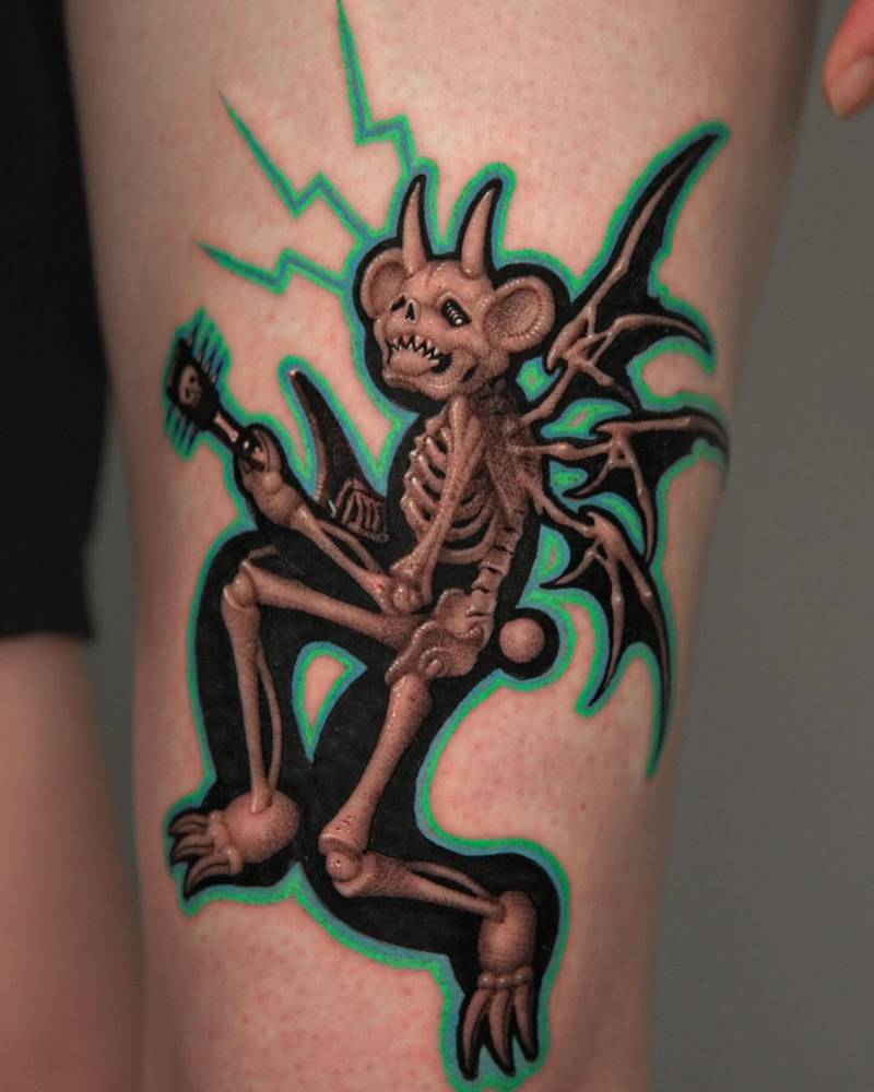 X-ray devil teddy playing the guitar tattooed on the thigh.