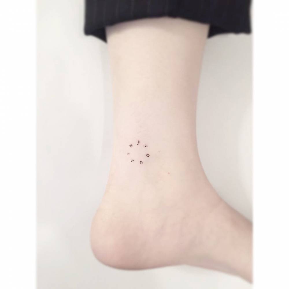 Circle lettering tattoo located on the ankle.