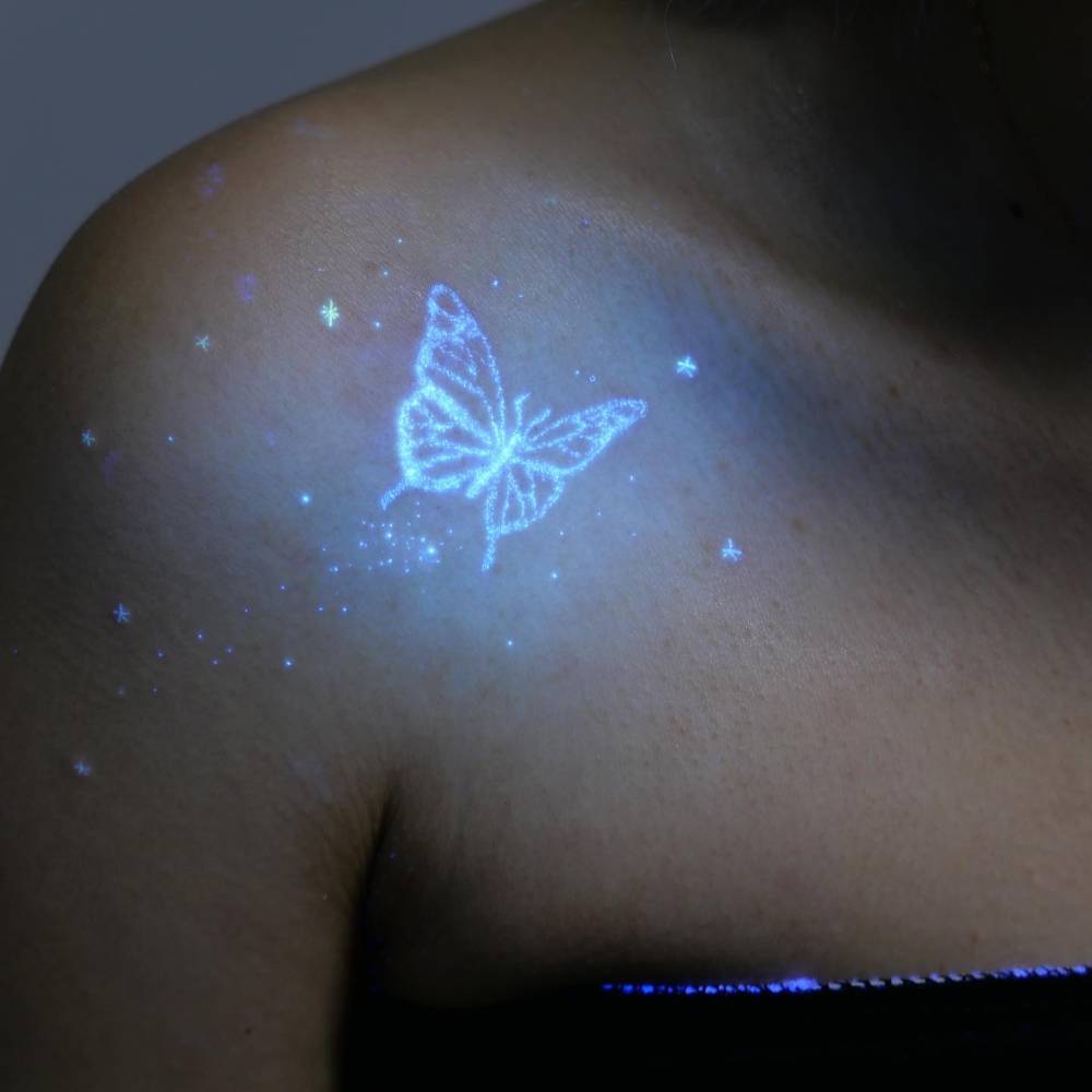 UV ink butterfly and stars tattoo located on the shoulder.