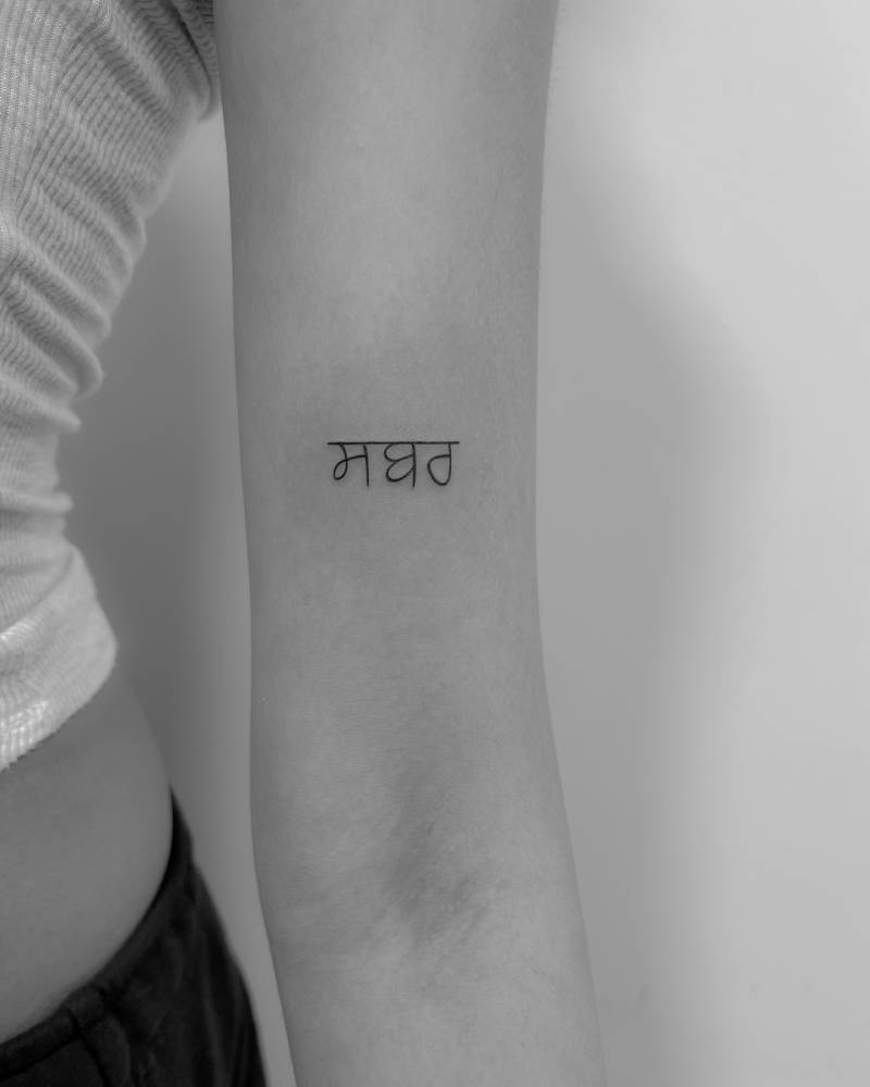 Punjabi lettering tattoo located on the bicep.