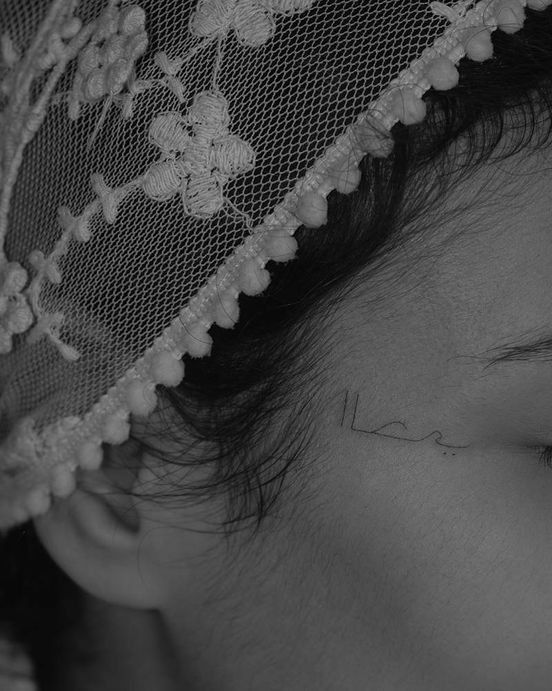 Arabic lettering tattoo located on the face.
