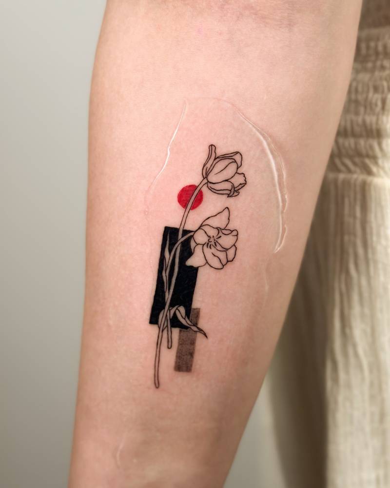 Lily flowers tattooed on the inner forearm, illustrative style.