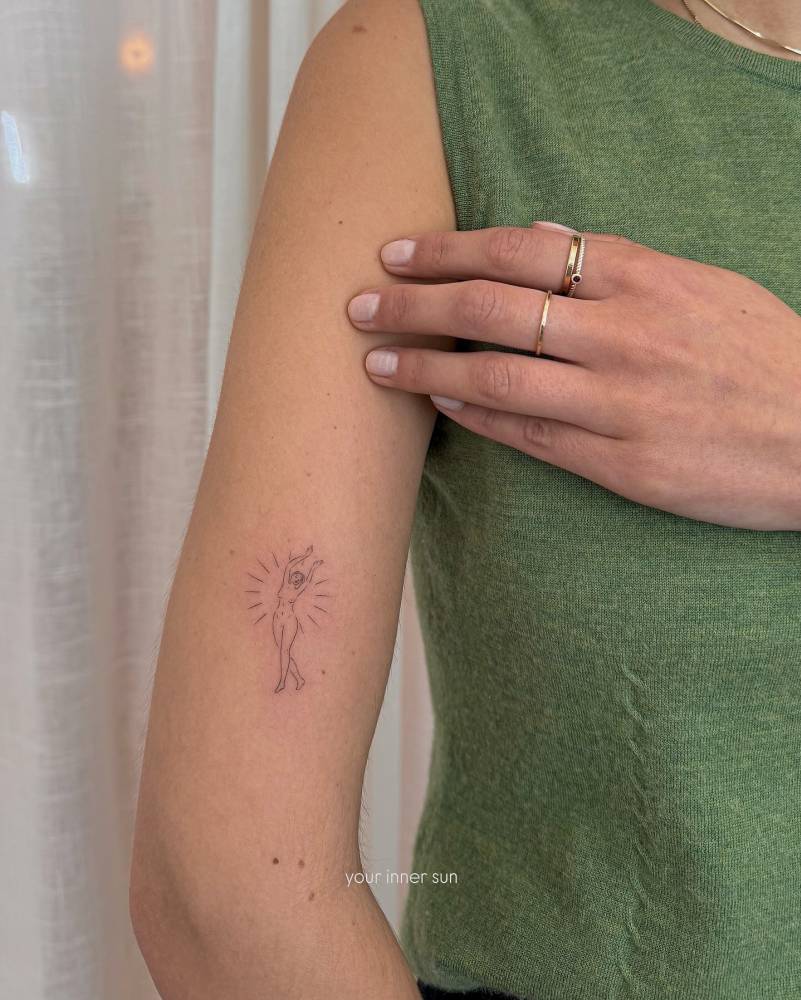 Nude lady in minimalistic style tattooed on the upper arm.