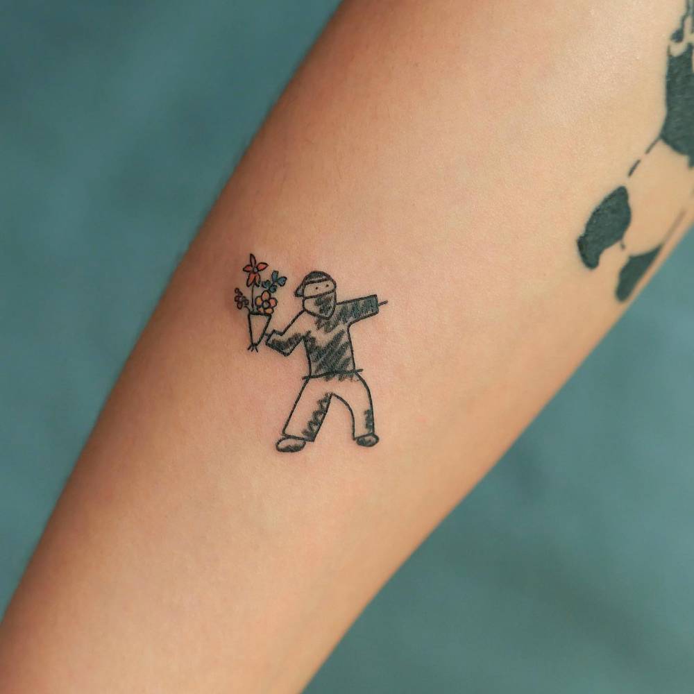 Flower Thrower tattoo located on the inner forearm.