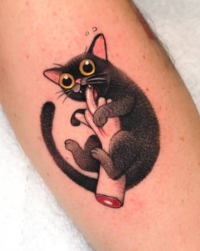 Black cat nibbling on a finger tattooed on the forearm.