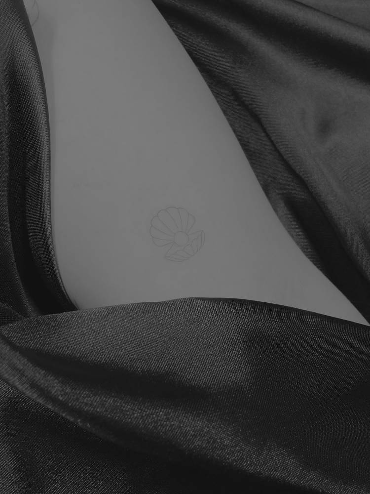 Fine line style scallop tattoo located on the inner arm.