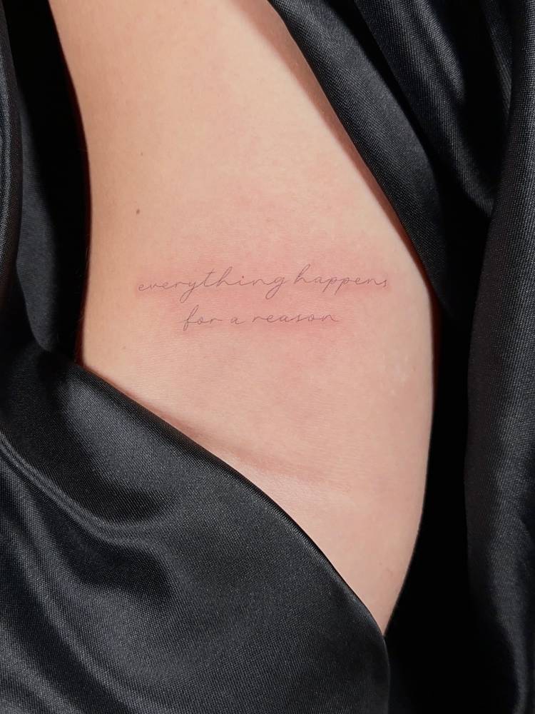 "Everything happens for a reason" lettering tattoo located on the bicep.