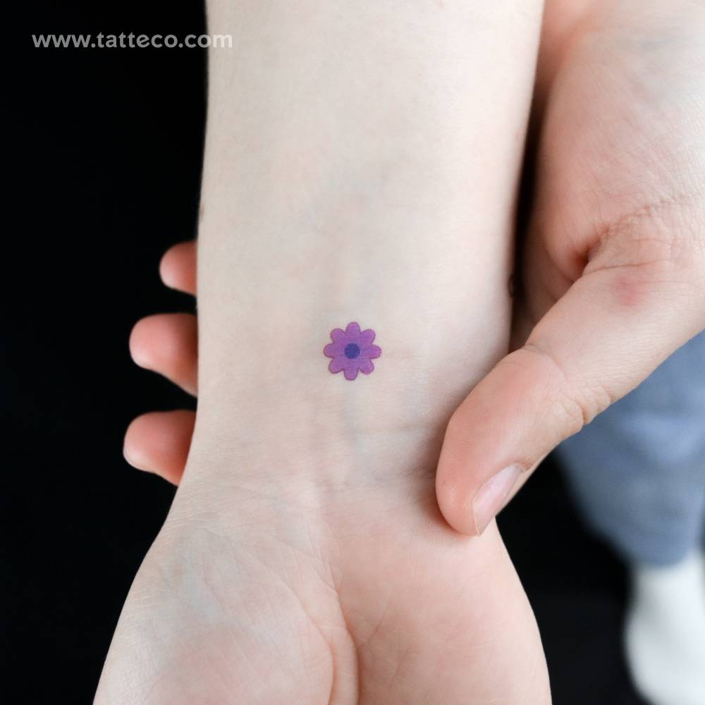 Minimalistic purple flower temporary tattoo placed on the wrist.