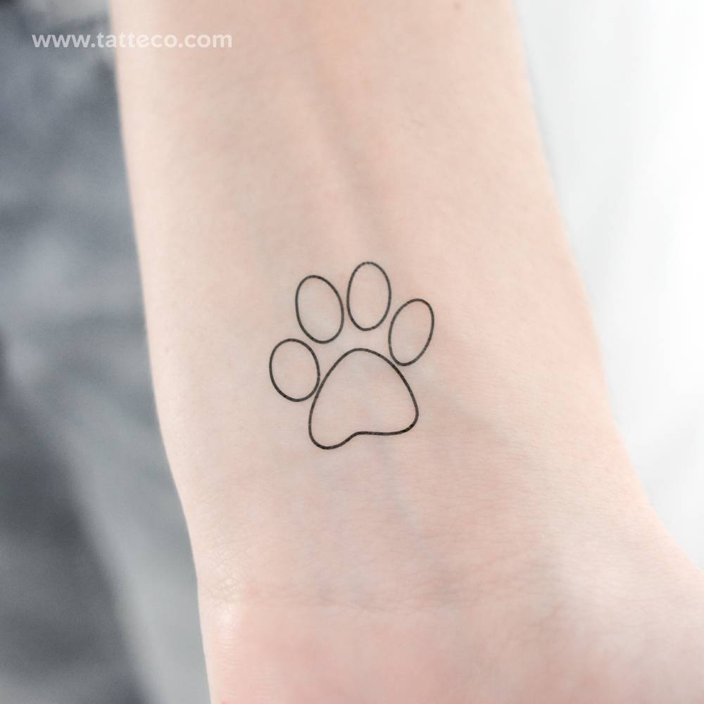 Fine line dog paw print temporary tattoo located on the wrist.