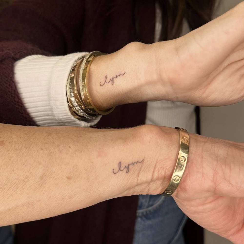 "ILYM" matching lettering tattoo for sisters.