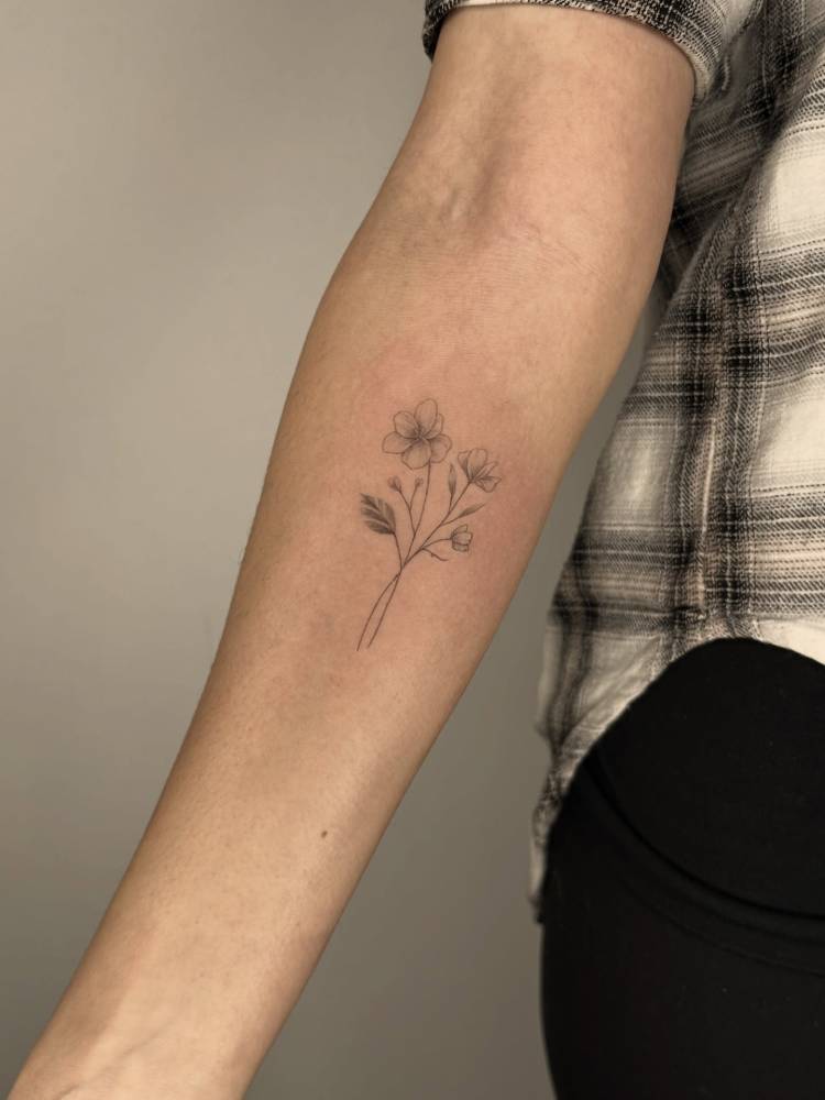 Illustrative style flower bouquet tattoo located on the inner forearm.