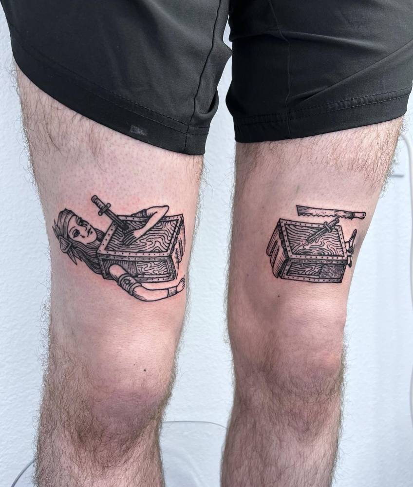 Individual matching woman sawed in half tattooed on the thighs.