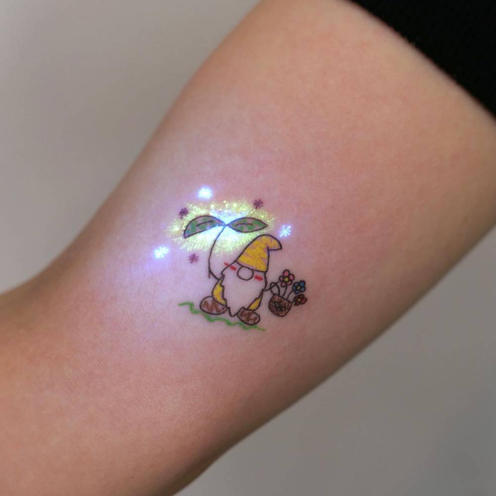 Cartoon style little gnome tattoo placed on the inner arm.