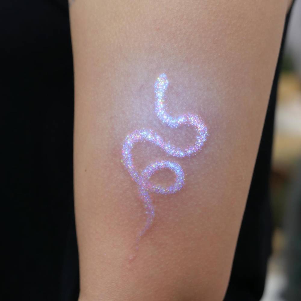 Glitter effect snake tattoo located on the upper arm.