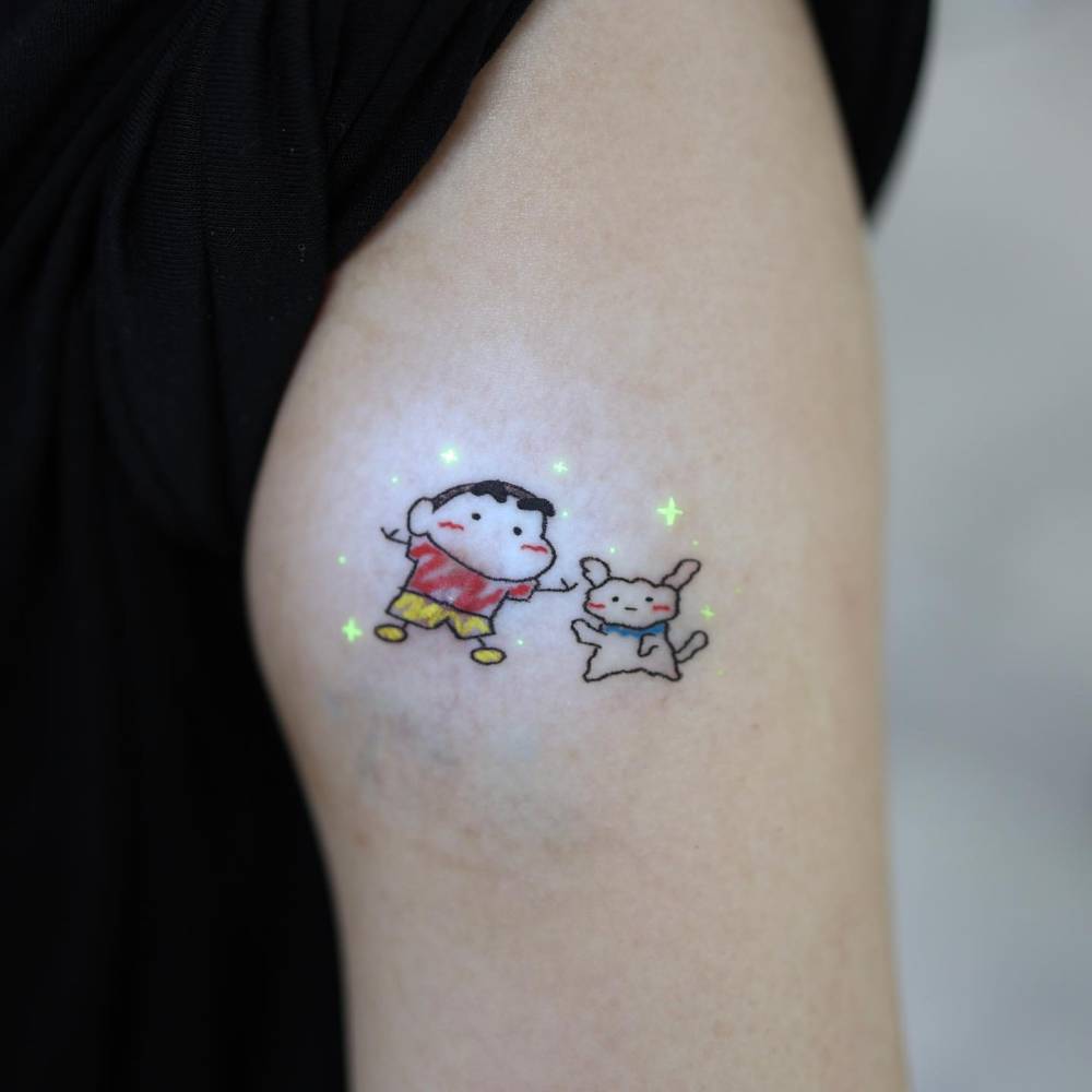 Shin-Chan tattoo in cartoon style located on the upper arm.