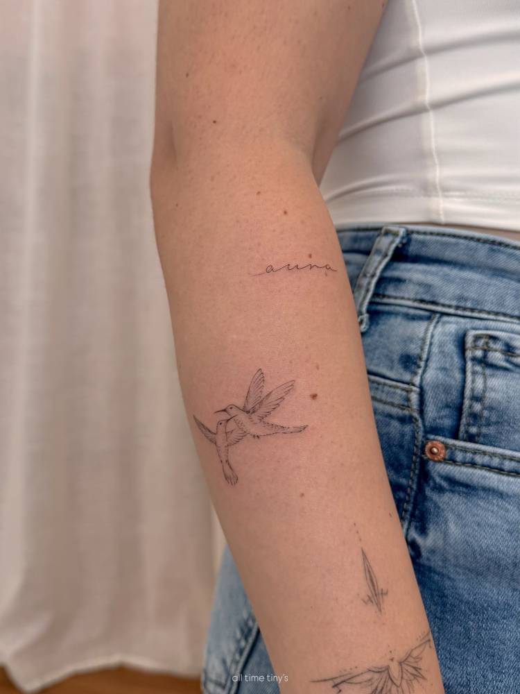 Little hummingbirds tattoo in fine line style located on the forearm.