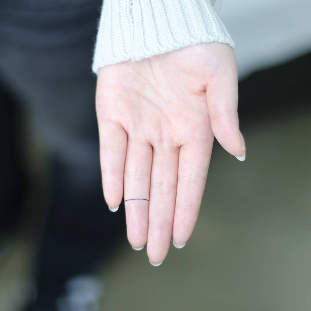 Little minimalistic ring tattooed on the finger.