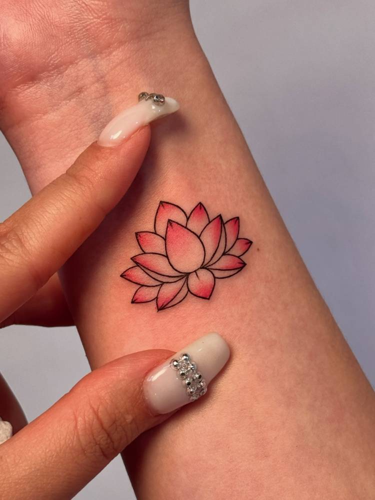 Illustrative style lotus flower tattoo located on the wrist.