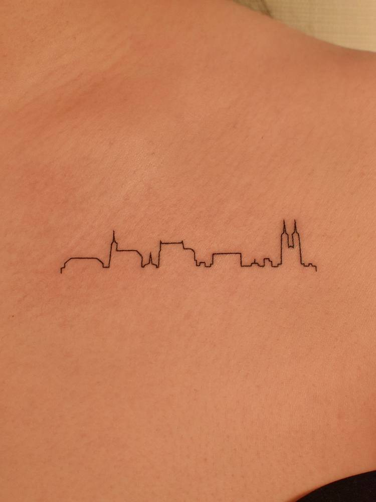 Fine line style Seoul skyline tattoo done on the collarbone.