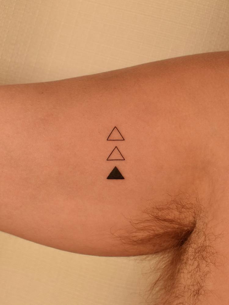 Triangles tattoo in minimalistic style done on the inner arm.