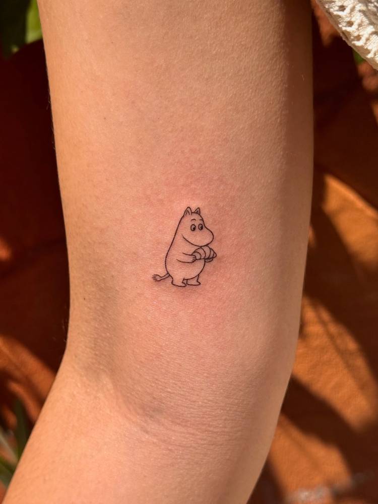 Fine line style Moomin tattoo located on the inner arm.